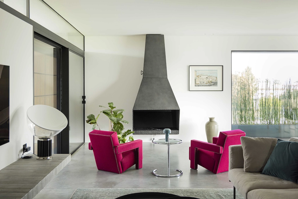 Casa CT — living room with concrete fireplace and red Cassina armchairs, interior design Vicenza