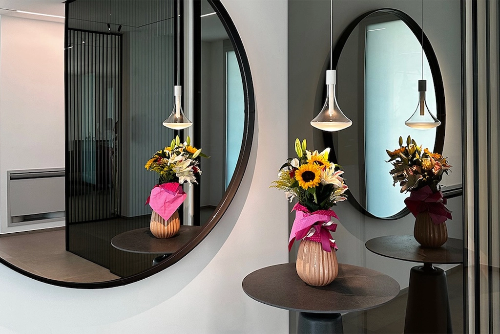 Casa UC — entrance hall with black round mirrors, stone side tables and Flos pendant lights, interior design Vicenza