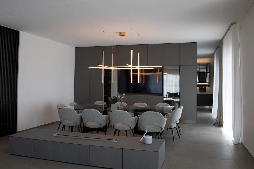 Casa UC — dining room with black glass table, grey Knoll chairs and geometric chandelier, interior design Vicenza
