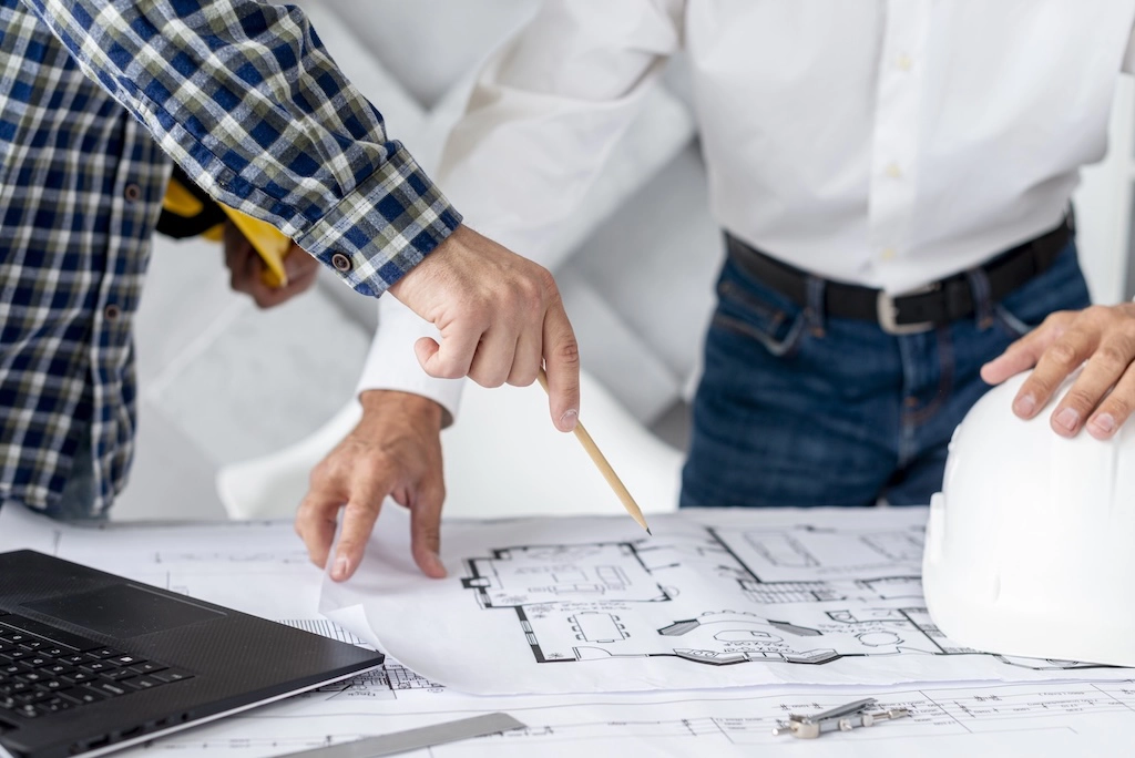 Technical consultation between interior designer and architect over a floor plan — iNSIDE Studio Design Vicenza
